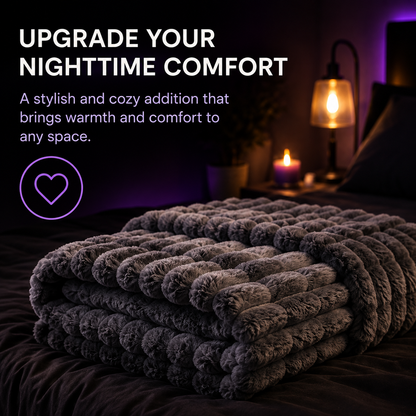 A dark gray chunky textured blanket is folded on a bed in a dimly lit bedroom scene with a bedside lamp and candle, accompanied by promotional text about upgrading nighttime comfort.