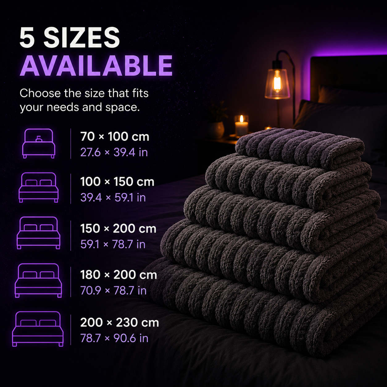 A stack of dark charcoal gray ribbed towels or bath mats on a bed in a dimly lit bedroom, with text on the left listing five available sizes and their dimensions in centimeters and inches.