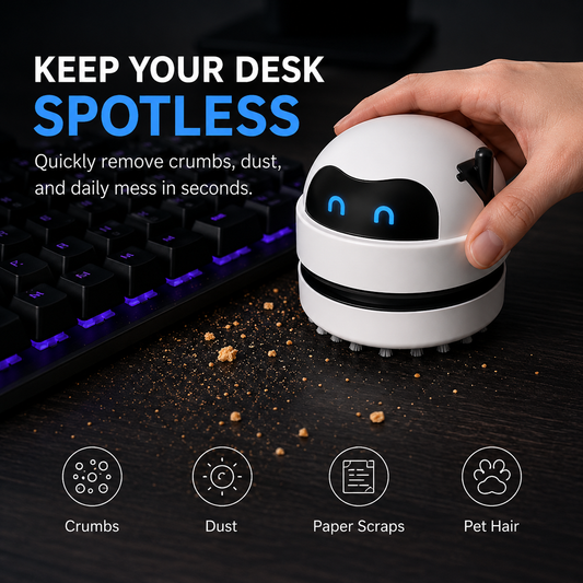 A white and black robotic vacuum cleaner being held by a hand on a dark desk next to a keyboard, with text reading 'KEEP YOUR DESK SPOTLESS' and icons for crumbs, dust, paper scraps, and pet hair.