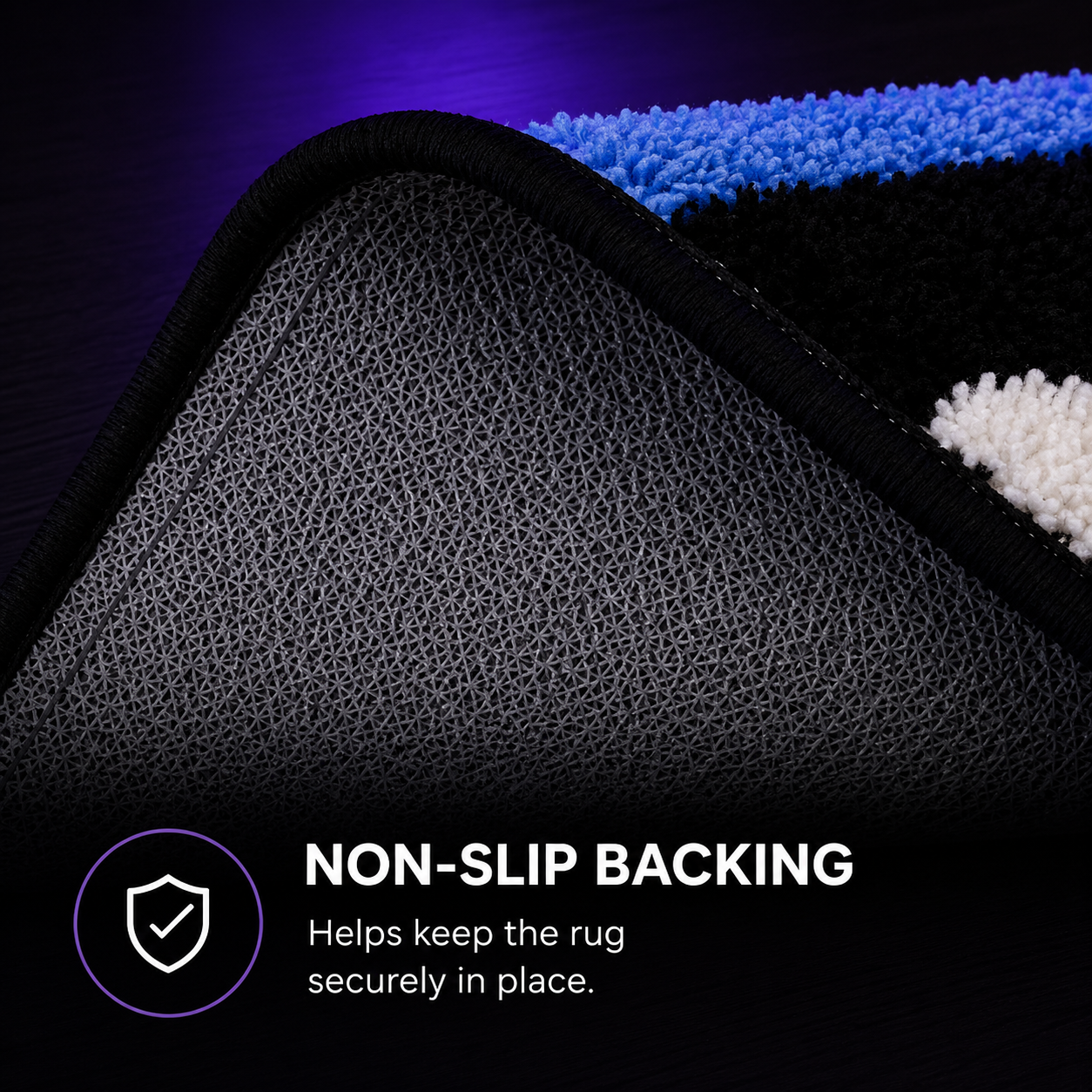 Close-up of a rug corner showing a black textured non-slip backing with a blue, black, and white plush top surface. Text on the image reads 'NON-SLIP BACKING Helps keep the rug securely in place.
